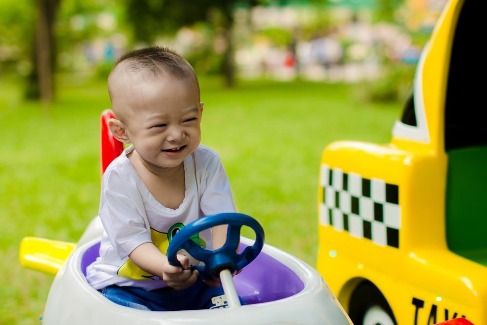 A toddler driving a car.