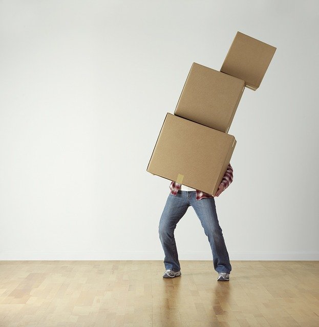 A man with moving boxes, ready to pack a moving truck.