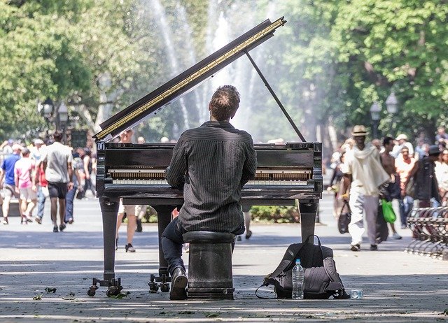 A man playing a piano in the park.