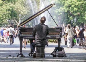 A man playing a piano in a park