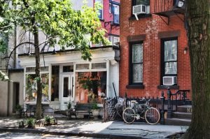 reasons why people move to NY, its red brick buildings, bikes and trees on the streets