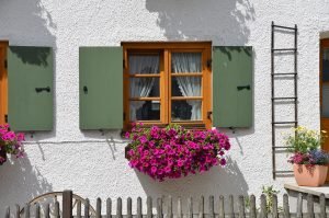 Wooden window with flowers under. 