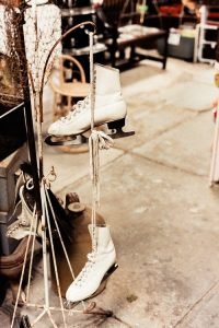 white ice skates hanging on the rack
