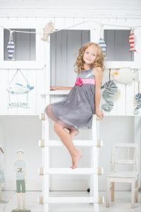Little girl standing on the ladders.