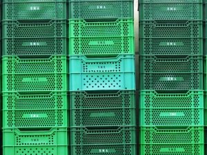 Green plastic containers stacked on top of each other. This is a great option if you're looking for reusable packing supplies.